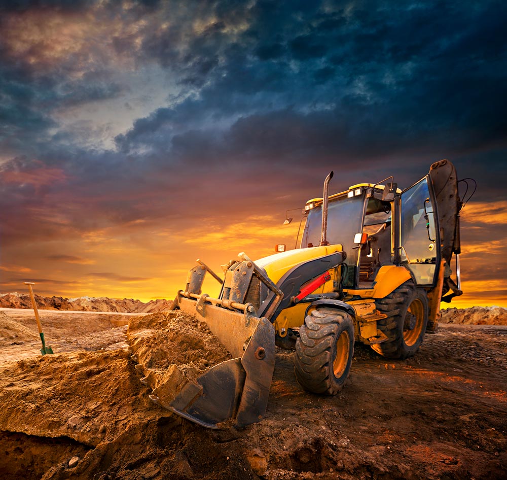 digger-GettyImages-535672679 Overholt Grading - commercial and residential grading excavating paving - bobcat on cleared land agasint a sky at dusk