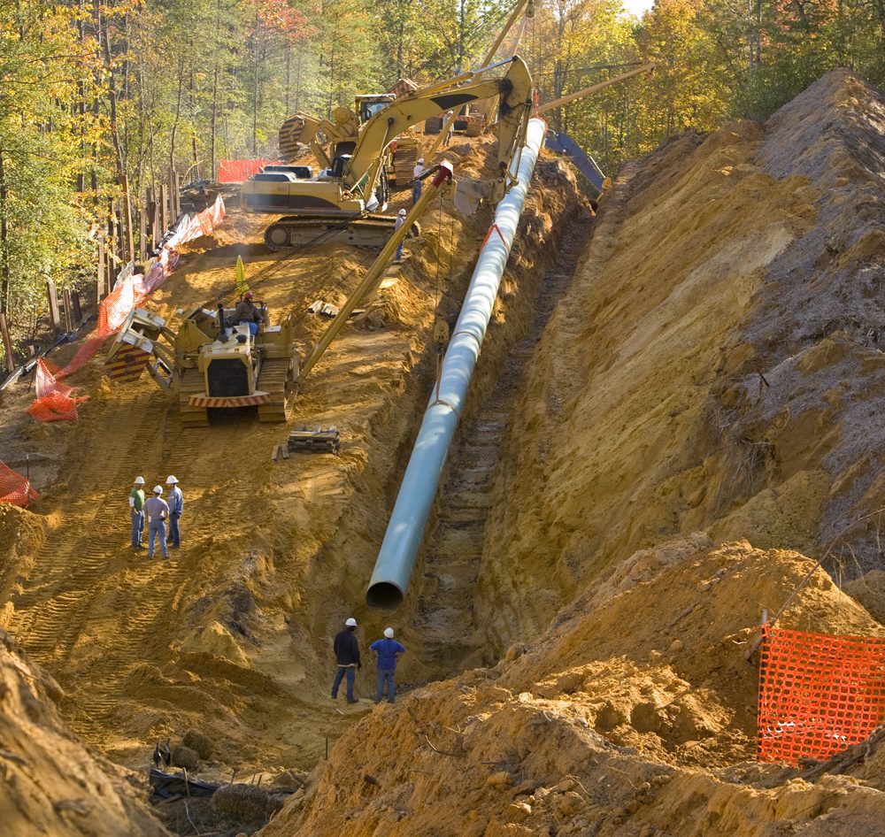 excavation-project-GettyImages-529431318 Overholt Grading - crew and equipment clearing trees and making a ditch for a pipe on a hill